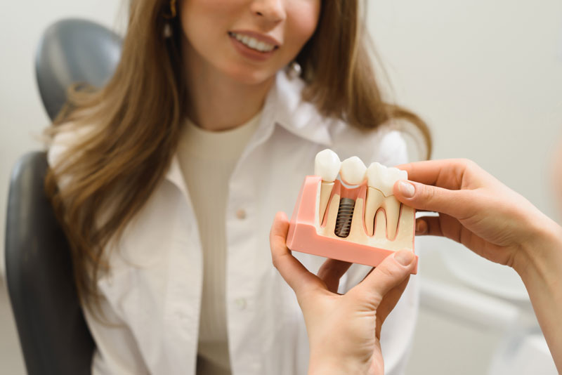 Dental Patient Getting Shown A Dental Implant Model During Her Consultation in Mission Viejo, CA