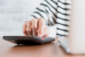 a dental patient calculating the cost of her dental implant treatment.