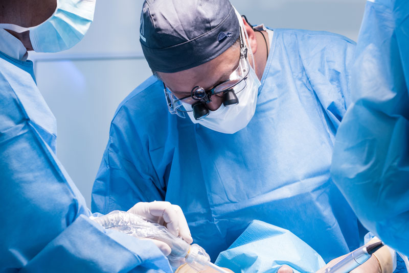 an oral surgeon performing a dental procedure surgery.