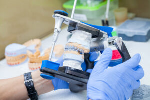 an oral surgeon working on a dental implant prosthesis model.